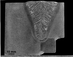 A cross-section of a welded metal joint etched to clearly reveal the macroscopic heat-affected zone, fusion line, and weld penetration depth.